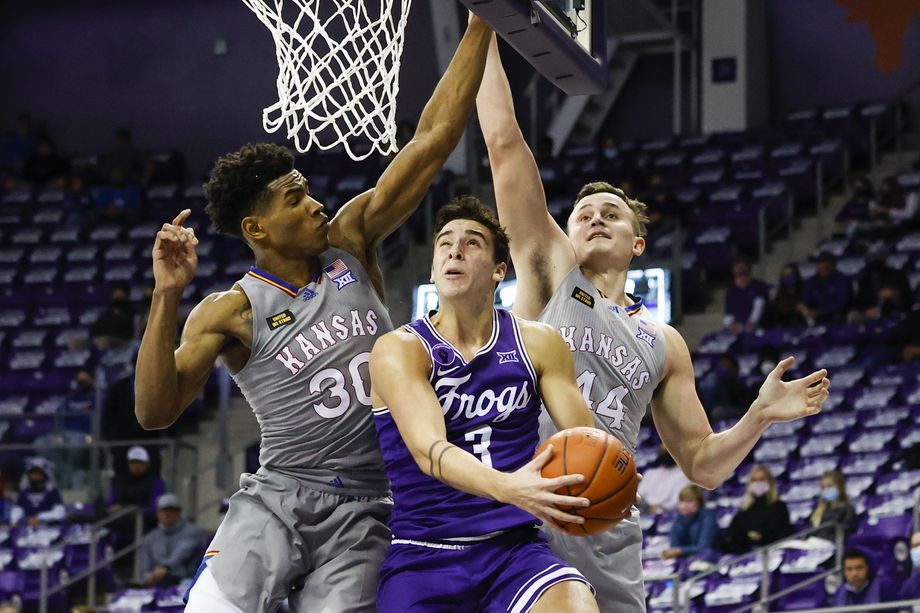 TCU PLAYER #3 jumping up to make a shot against two Kansas players