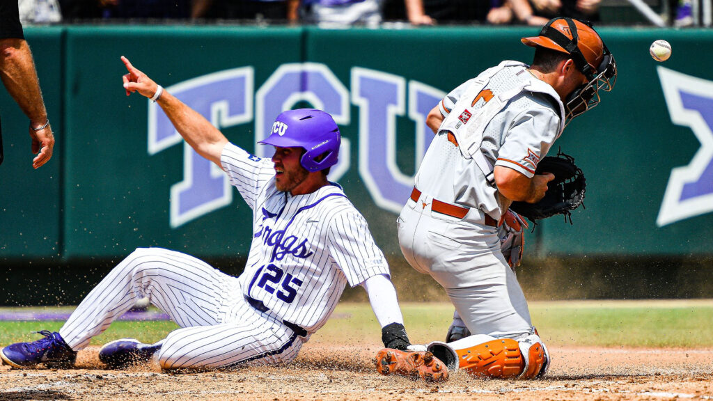 Horned Frogs baseball player slides past the Longhorn catcher over home plate pointing to the crowd while scoring a run for TCU